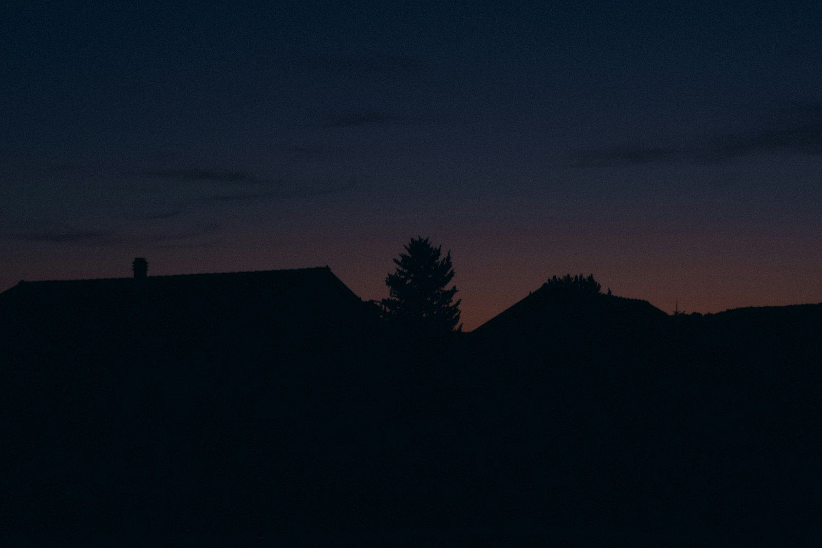 Silhouettes of houses against a twilight sky